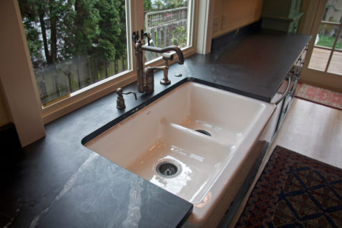 A large Double Fireclay Sink and bordering soapstone counters create a large, bright workspace.